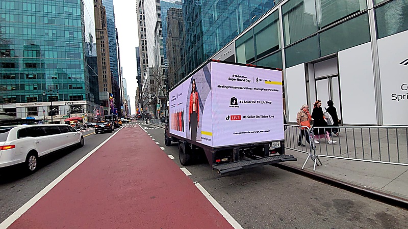 Mobile Billboard truck displaying a promotional campaign in a business district