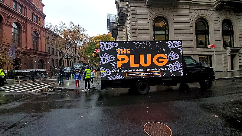 Mobile mobile billboard truck promoting The Plug in a city street